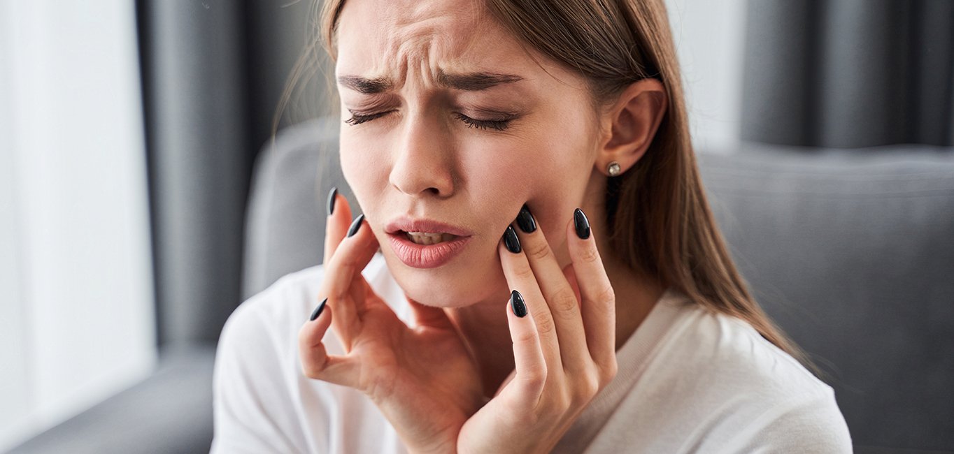 A closeup of a girl suffering tooth pain