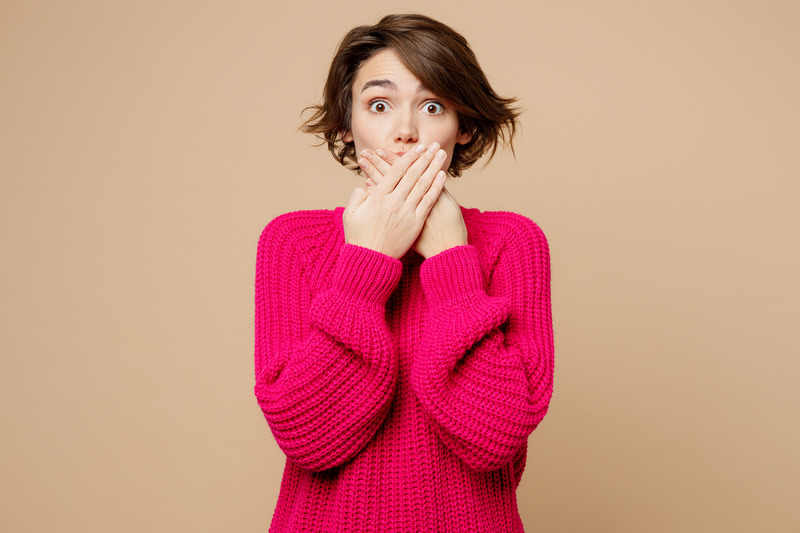 Patient covering their mouth after losing a veneer